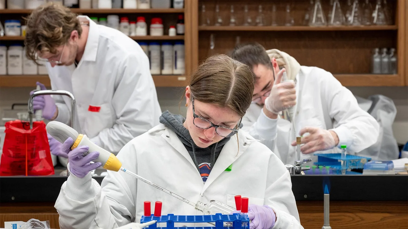 Students pipetting samples at a laboratory bench